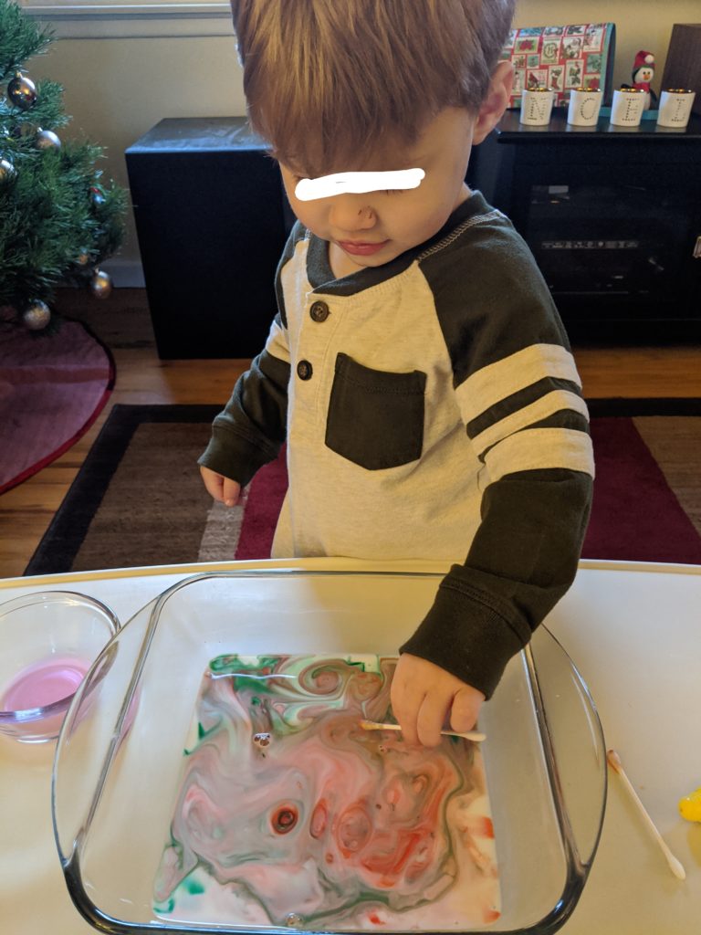 Little Man trying the Magic Milk Christmas Activity.